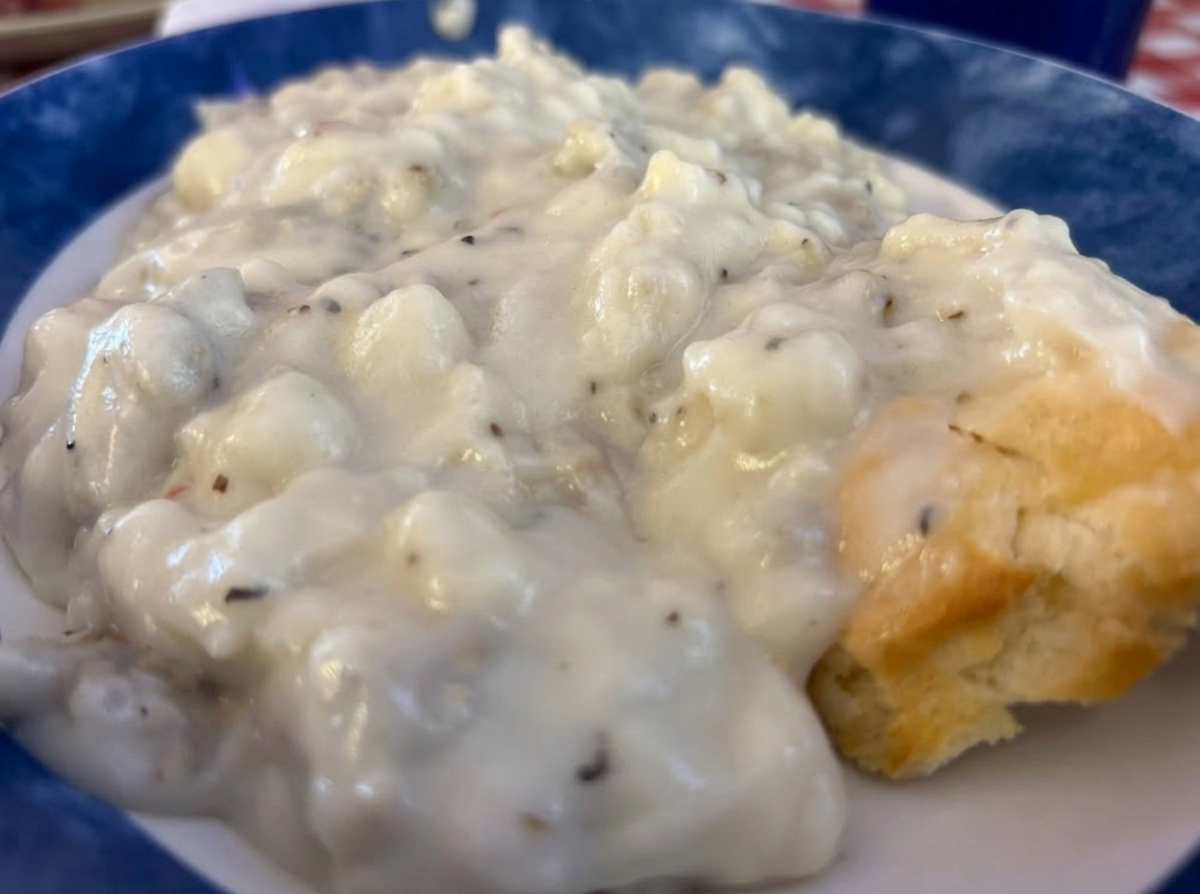 Biscuits and sausage gravy on a blue-rim plate
