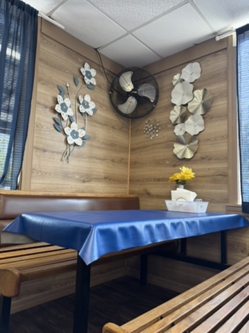 A booth with a blue table and metal starburst flower wall accents