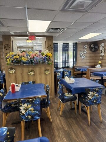Barbara's dining room with royal-blue floral chair slipcovers, blue tablecloths and a large fresh floral arrangement