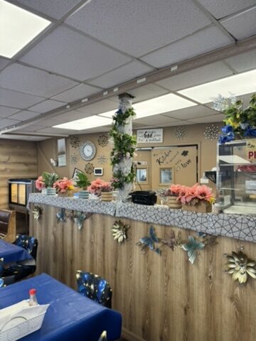The hostess counter with fresh flowers and wood paneling